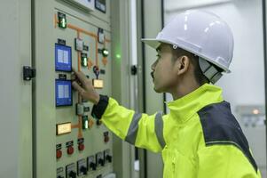 Electrical engineer man checking voltage at the Power Distribution Cabinet in the control room,preventive maintenance Yearly,Thailand Electrician working at company photo
