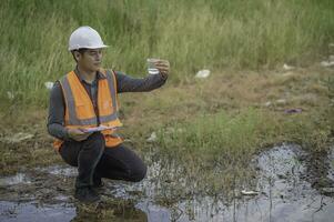 Environmental engineers inspect water quality,Bring water to the lab for testing,Check the mineral content in water and soil,Check for contaminants in water sources. photo