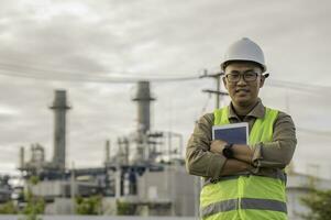 Asian man petrochemical engineer working at oil and gas refinery plant industry factory,The people worker man engineer work control at power plant energy industry manufacturing photo