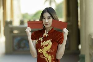retrato hermosa mujer asiática en vestido cheongsam, gente de tailandia, concepto de feliz año nuevo chino, dama asiática feliz en vestido tradicional chino foto