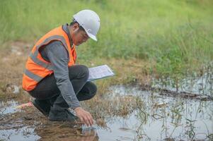 Environmental engineers inspect water quality,Bring water to the lab for testing,Check the mineral content in water and soil,Check for contaminants in water sources. photo