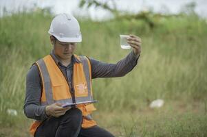 los ingenieros ambientales inspeccionan la calidad del agua, llevan el agua al laboratorio para su análisis, verifican el contenido de minerales en el agua y el suelo, verifican los contaminantes en las fuentes de agua. foto