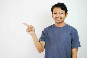 sonriente o contento hermoso joven asiático hombre con su dedo señalando aislado en blanco antecedentes con Copiar espacio foto