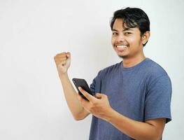 handsome smiling or happy Asian young man casual outfit in Navy t-shirt holding smart phone chatting on white isolated background. photo