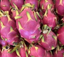 Pinkish red spiky shaped dragon fruit or buah naga photo.Yummy, sweet, and healthy fruit pile on traditional market photography. photo