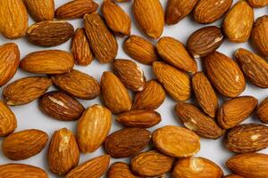 Almonds on white background. Raw peeled almond nuts texture photo