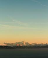 Alpes montañas por puesta de sol foto