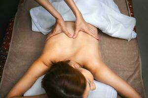 beautiful woman receiving hot stone massage in spa photo