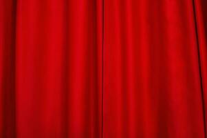 Red fabric as a background. Red light-absorbing curtain. The window is closed with a curtain. photo