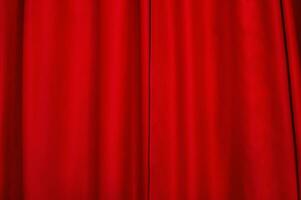 Red fabric as a background. Red light-absorbing curtain. The window is closed with a curtain. photo