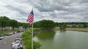 patriottisch tafereel. Amerikaans vlag golvend in voorkant van zakelijke kantoor gebouw. trots weergegeven vlag in bedrijf centrum met gespiegeld reflecties. video