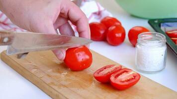 fechar acima Visão do mulher mãos corte tomates com uma chefs faca video