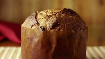 Italiaans panettone gevuld met geglaceerd vruchten. traditioneel Kerstmis brood gevuld met droog fruit Aan een rustiek houten tafel video