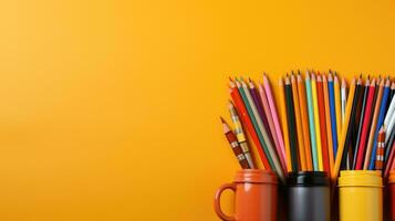 School supplies stationery, colour pencils, paints, paper on pastel orange background, back to school concept with free copy space for text photo