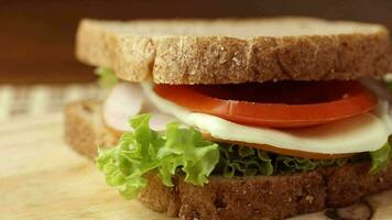 schließen oben gesund hausgemacht Sandwich von ganze Korn brot, Kopfsalat, Mozzarella, geräuchert Hähnchen Brust und Tomate auf Schneiden Tafel video