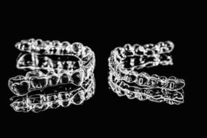 Invisible aligners retainers of teeth lie on the mirror on a black and white photograph photo