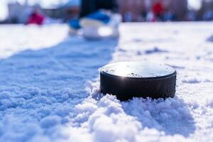 hockey puck lies on the snow macro photo