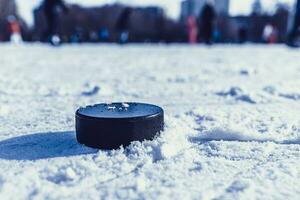 hockey puck lies on the snow close-up photo