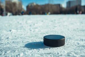 hockey puck lies on the snow close-up photo