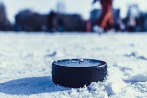 hockey puck lies on the snow close-up photo