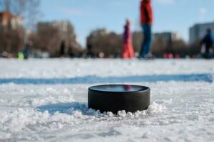 hockey puck lies on the snow macro photo