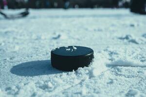 hockey puck lies on the snow close-up photo