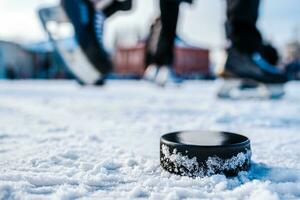 black hockey puck lies on ice at stadium photo