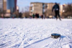 hockey puck lies on the snow macro photo