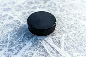 black hockey puck lies on ice at stadium photo