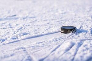 hockey puck lies on the snow close-up photo