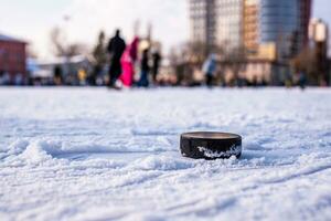 hockey puck lies on the snow macro photo