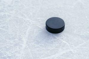 hockey puck lies on the snow close-up photo