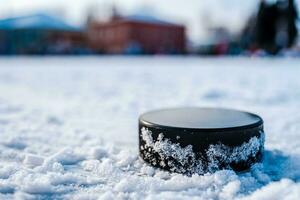 hockey puck lies on the snow macro photo