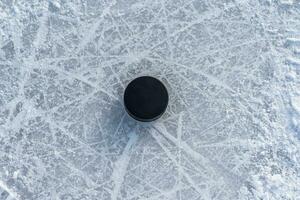 hockey puck lies on the snow close-up photo