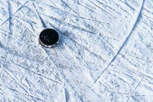 hockey puck lies on the snow close-up photo