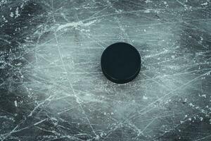 hockey puck lies on the snow macro photo