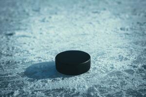 hockey puck lies on the snow close-up photo