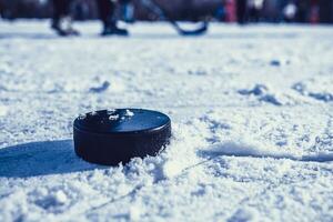 hockey puck lies on the snow macro photo