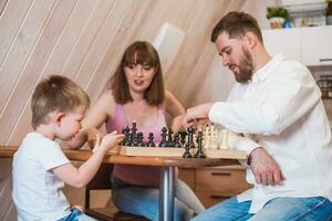 Happy family playing chess in the kitchen photo