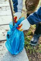 un hombre plantas un joven Fruta árbol. el granjero desempaqueta un nuevo planta de semillero y pone eso en el suelo. el concepto de ambiental proteccion y ecología foto