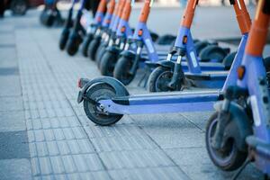 Electric scooters are parked in the city center. Modern public mobile transport photo