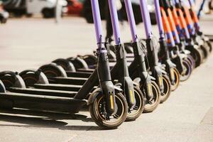 Electric scooters are parked in the city center. Modern public mobile transport photo