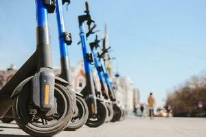 Electric scooters are parked in the city center. Modern public mobile transport photo