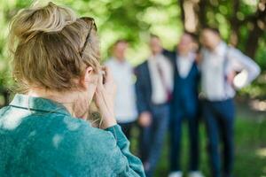 The wedding photographer photographs the guests of the bride and groom in nature photo