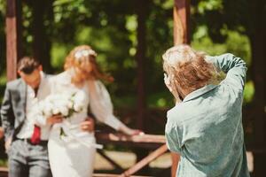 A wedding photographer photographs a couple in nature on a sunny day photo