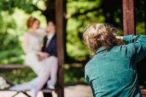 A wedding photographer photographs a couple in nature on a sunny day photo