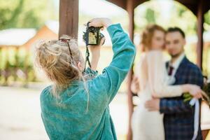 un Boda fotógrafo fotografias un Pareja en naturaleza en un soleado día foto