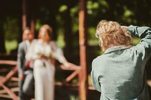 A wedding photographer photographs a couple in nature on a sunny day photo