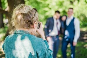 The wedding photographer photographs the guests of the bride and groom in nature photo