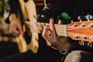 hombre jugando acústico guitarra y jugando acordes de cerca foto